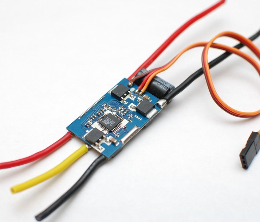 A small electronic speed controller circuit board with red and black power wires, motor wires and a servo signal lead
